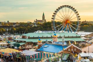 Panoramaaufnahme aus der Luft mit Blick auf das Festgelände und dem Riesenrad im Hintergrund