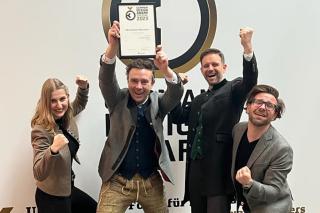 Agentur RED feiert mit dem Award in der Hand