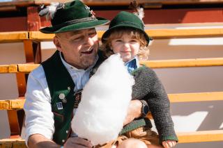 Mann mit Kind in bayerischer Tracht mit einer Zuckerwatte