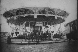 Hugo Haase auf dem Oktoberfest mit Personengruppe vor dem Karussell, Oktoberfest 1905.