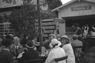 Gäste in einem Biergarten auf dem Oktoberfest in den 1930er Jahren.