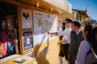 Gäste an einem offiziellen Informationsstand auf dem Oktoberfest Gäste an einem offiziellen Informationsstand auf dem Oktoberfest